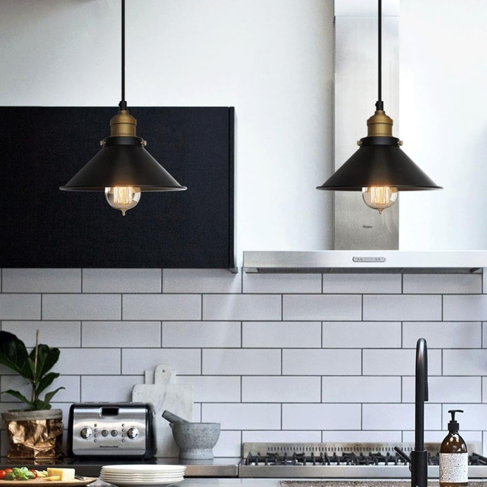 Pair of black cone pendant lights with brass lampholders in a white kitchen