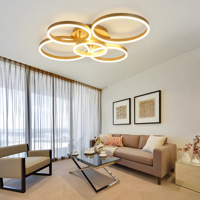 Circle gold LED ring flush ceiling light glowing warm white over a modern living room