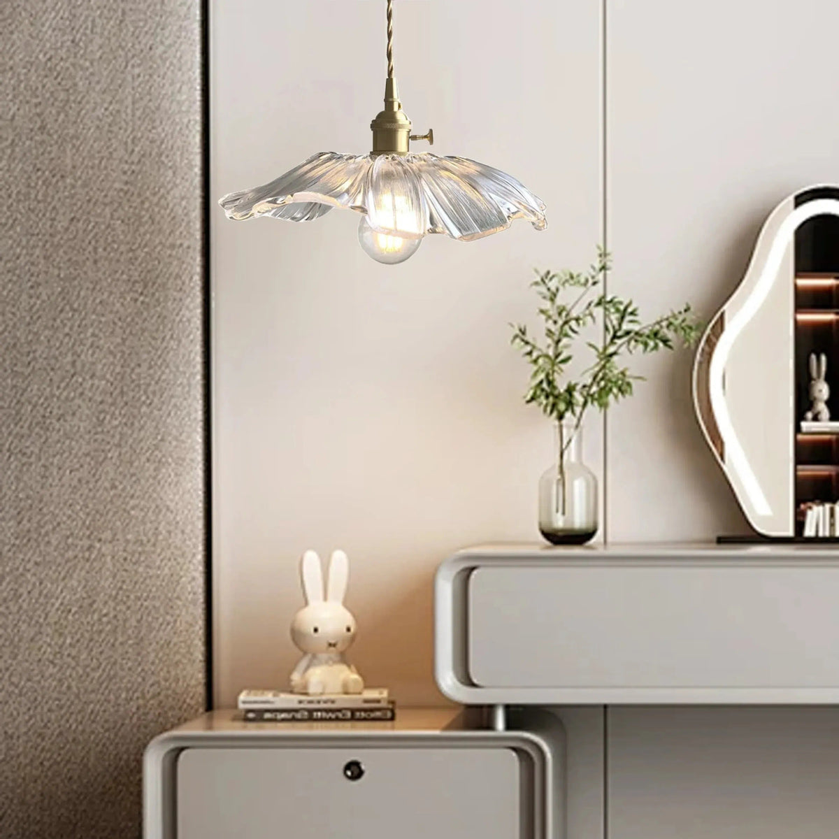 Clear flower glass pendant light beside a bedside table