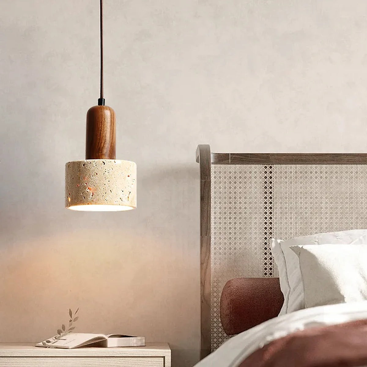 Remy travertine pendant with walnut neck glowing beside a bed