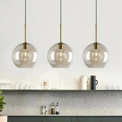 Three Sienna cognac glass globe pendant lights above a kitchen worktop