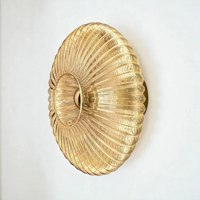 Solene ribbed glass wall light in milky white, switched on